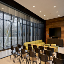 Within a meeting room with blinds inside the glass partition walls of QbiQ
