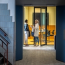 Hallway with glass partitions and door at the end